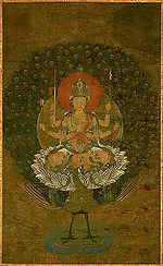 Frontal view of a deity with six arms seated on a peacock.