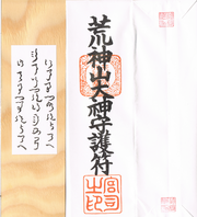 An example of a shinsatsu (from Kōjinyama Shrine in Shiga Prefecture): a plaque with the names of the shrine's kami – Homusubi, Okitsuhiko and Okitsuhime – written in Jindai moji and its paper casing on which is written the name of the shrine or the epithet of its deity – in this case, Kōjinyama-no-Ōkami (荒神山大神, 'Great Deity of Kōjinyama (Shrine)') – and stamped with the seals of the shrine (middle) and its priest (bottom).