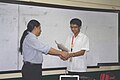 Wikimedia Philippines Vice President Jojit Ballesteros receives a Certificate of Appreciation from the organizers of the UST Debate Forum