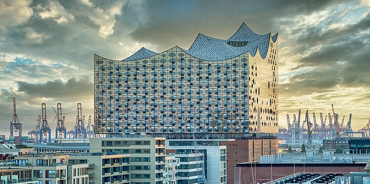 Elbphilharmonie viewed from the HafenCity against the background of harbor cranes.