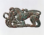 狼纹青铜带饰，为宁夏南部及甘肃东南的游牧文物中所特有。与塞西亚风格的巴泽雷克文化相近。公元前4世纪。[27][24]