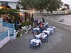 Patrons dining outdoors at a Greek restaurant