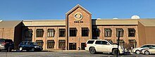 A two-story office building with a prominent CBS eye sign and satellite dishes on the roof.