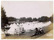 Rows of circular tents on an open grass field in Golden Gate Park, 1906