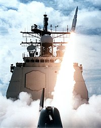 A missile firing from USS Vincennes, the mast visible behind a cloud of smoke from the launch