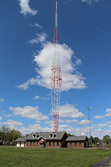 A radio tower shaped like a diamond and guy-wired at the widest point of the diamond.