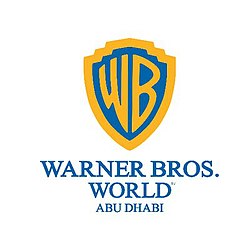 Warner Bros. World Abu Dhabi logo, gold shield with a blue inner section containing the letters "WB" in gold writing. Under the shield are the words "Warner Bros. World Abu Dhabi"