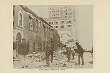 An image showing workers cleaning up debris along a street
