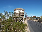 Goldfield Ghost Town. Goldfield was a mining town established in 1893 next to the Superstition Mountain. When the mine vein faulted, the grade of ore dropped and the town eventually became a ghost town. The town and its historic buildings were revived as a tourist attraction. The ghost town is located at 4650 N, Mammoth Mine Road in the town of Apache Junction, Az.