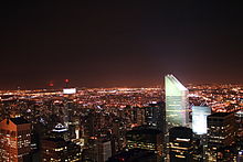 Night view of Manhattan's skyline as seen from Rockefeller Center. The Citigroup Center's slanted roof is visible on the right side of the image.