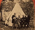 Four men in front of a tent with a sign for the Boston Daily Advertiser, 19th century