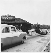 A toll booth with several cars at it on the Merritt Parkway