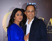 Shah and her husband looking at the camera