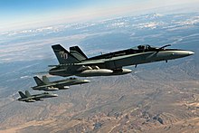 Photo of three modern fighter aircraft flying in formation over a desert