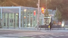 Photo of a largely completed modern light rail station entrance with glass panelling.