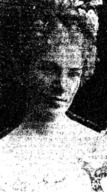 A young white woman with an updo decorated with flowers.