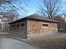 A square stone building in a park