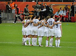 Seven American soccer players next to each other in a pitch.