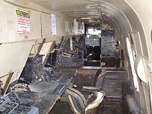 View inside the Shackleton cabin, looking forward past the row of operator desks along the port side.