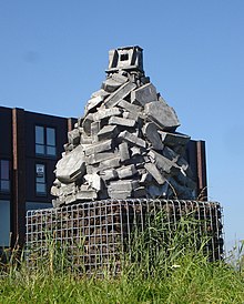 Photo of a sculpture, which can be described as a big basket made from Gabion which is filled with basalt.