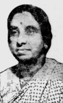 Middle-aged Indian woman wearing a print sari, her dark hair dressed low to the nape
