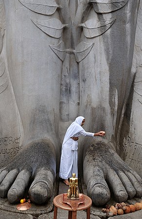 一名耆那教妇女在印度卡纳塔克邦的Shravanabelagola为Bhagwan Bahubali Gomateswara雕像的脚进行Abhishek仪式。