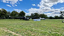A picture of a blue Neptune and white Heron aircraft sitting in a grassy paddock, the future site of the new HARS Parkes museum facility.