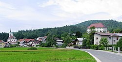 Dobrova with the parish church (left), the rectory and convent (top right), and Dobrova Hill in the background