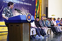 Rodrigo Duterte speaks on a podium at an assembly