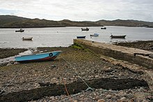 Photograph of the Culkein Drumbeg jetty and several small boats in the water