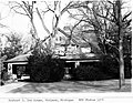 A house surrounded by large trees and bushes