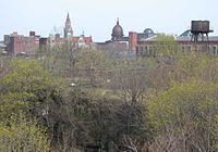 Paterson's skyline, showing the canyon of the Passaic River in the foreground. The area along the river was formerly the site of most of the mills that flourished throughout Paterson's history.