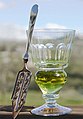 Image 30A reservoir glass filled with a naturally colored verte absinthe, next to an absinthe spoon (from List of alcoholic drinks)