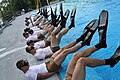 Students perform physical training on the pool deck.