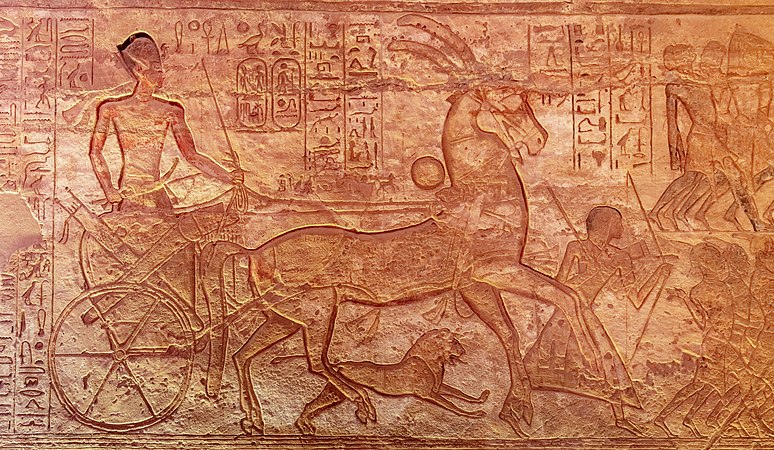 图为埃及阿布辛贝勒神庙中代表法老拉美西斯二世的浮雕，描绘的是他在对赫梯帝国的卡迭石战役中坐在战车上的形象。