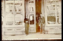 Two men stand in front of Dickinson's Seed Storefront in the 1860s.