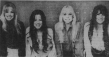 Black and white photo of four women standing in a row