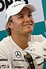 A man in white racing uniform and baseball cap