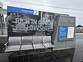 The "Rich in good fellowship" Noble Park suburb mural permanently wrapped around the background behind the platform signage and seating, October 2024