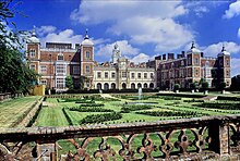 An image of Hatfield House (a large, brick, castle-like building with multiple stories)