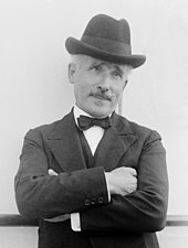 head and shoulder shot of a man in a suit with moustache