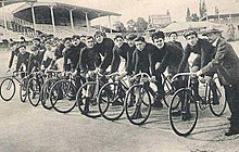 A lineup of men on bicycles