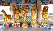 The golden statues at the Rua Yai City Pillar Shrine in Suphan Buri, Thailand