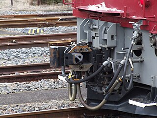 JNR Class EF81 the AAR coupler on the right (far side) of the Shibata coupler. The Janney coupler is shown in position on the centerline and the Shibata coupler is shown as swung out of the way. There is a pivot in common allowing both to swing.