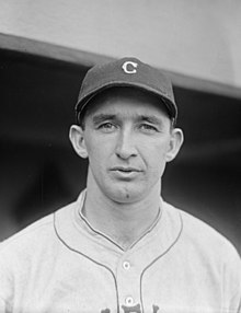A man in a white baseball jersey and dark cap with a "C" on the front.