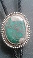 Variscite and silver bolo tie. This variscite specimen contains inclusions of white crandallite and is from Clay Canyon near Fairfield, Utah.