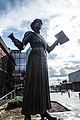 Annie Kenney's statue in Oldham with "Votes for Women"
