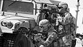 Soldiers take cover behind a HMMWV during live fire training.