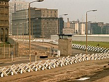 A photograph showing the Czech hedgehogs and a guard tower at the Berlin Wall.