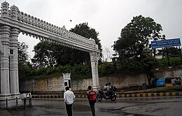 Large, rectangular stone arch, with pedestrians and motorcyclists